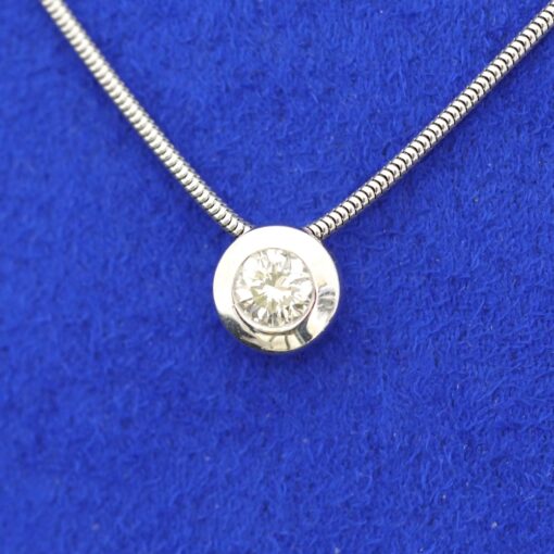 Colgante con brillante de 0,45 y cadena. Montados en oro blanco de 18 Ktes.