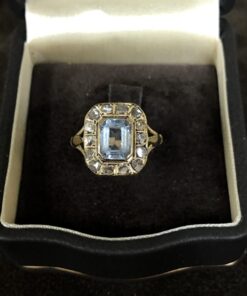 Sortija con piedra sintética con orla de diamantes 0,60 cts montado en oro amarillo de ley 18kts