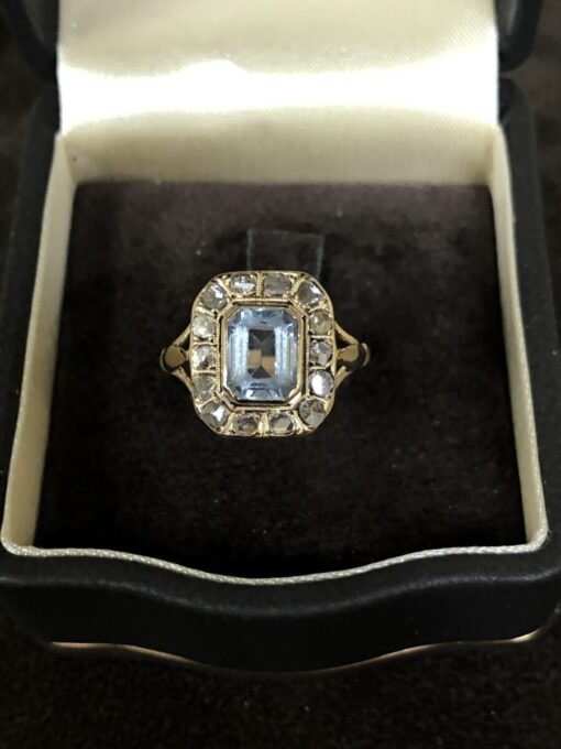 Sortija con piedra sintética con orla de diamantes 0,60 cts montado en oro amarillo de ley 18kts