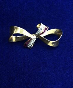 Broche en forma lazo con brillantes  montado en oro amarillo de ley 18kts