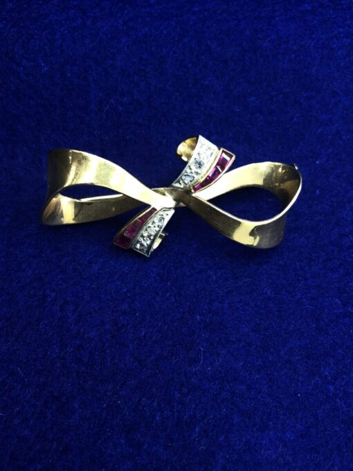 Broche en forma lazo con brillantes  montado en oro amarillo de ley 18kts