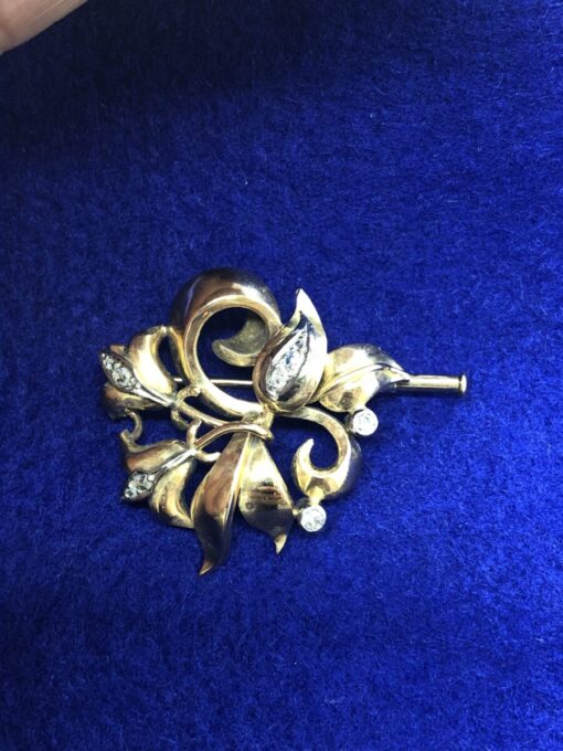 Broche  con forma  flor y brillantes  montado en oro amarillo de ley 18 kts