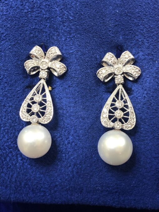 PENDIENTES PERLAS CULTIVADAS CON BELLA MONTURA DE BRILLANTES Y LAZO 0,50CTS EN ORO BLANCO DE LEY 18KTS.