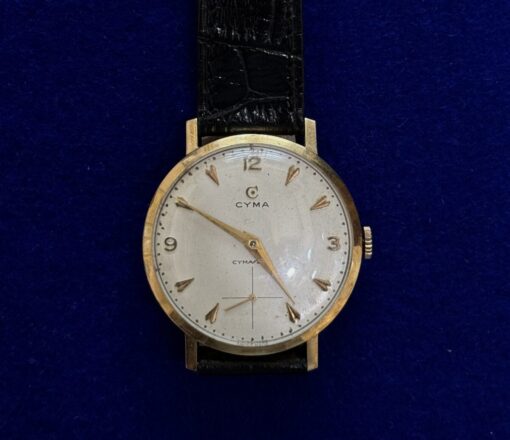 RELOJ CYMA DE CUERDA. CON PULSERA DE CUERO NEGRO. EN ORO 18KTS.
