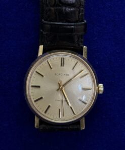 RELOJ LONGINES DE CUERDA. CON PULSERA DE CUERO NEGRO. EN ORO 18KTS.