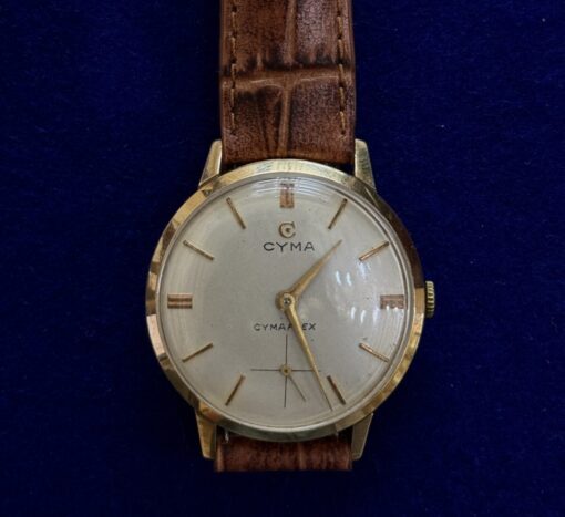 RELOJ  CYMA DE CUERDA MANUAL Y PULSERA DE CUERO MARRÓN, EN ORO 18KTS.
