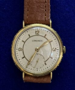 RELOJ VINTAGE LONGINES, DE CUERDA, CON PULSERA DE CUERO MARRÓN. EN ORO 18KTS.