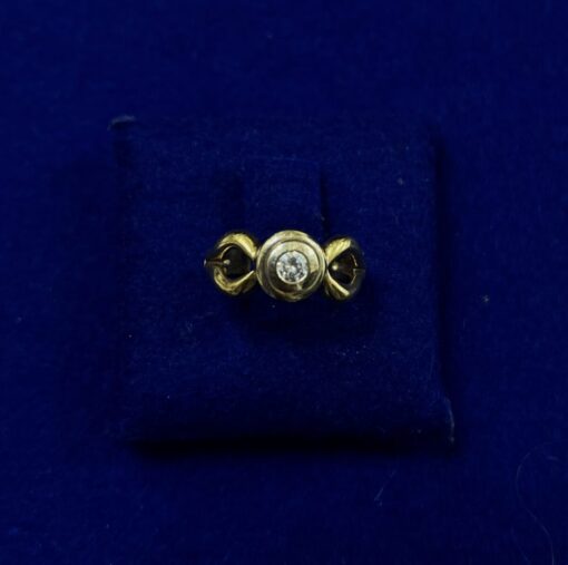 Solitario de brillante 0,20 cts con forma de brazo, montada en oro de ley 18 kts.
