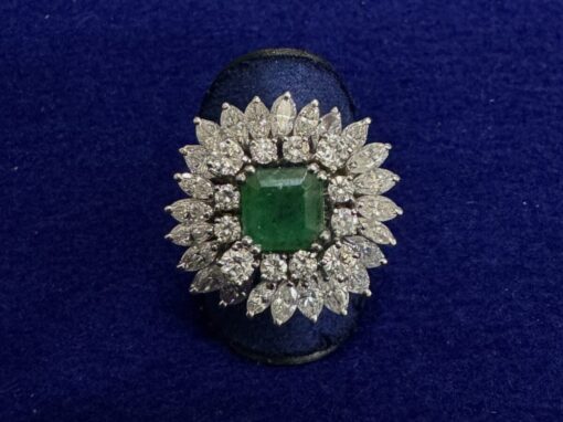 Sortija cuajada de brillantes 3,80cts con esmeralda central. Montada en oro blanco de ley 18kts.