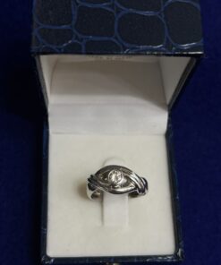 Solitario con brillante central 0,25cts en chatón y brazos cruzados. Montado en oro blanco de ley 18kts.