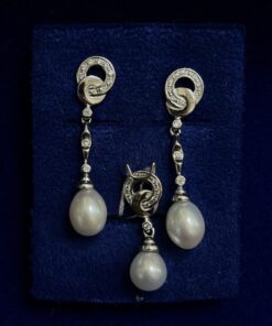 Juego de pendientes largos con colgante de perlas y circonitas. Montado en oro blanco de ley 18kts.