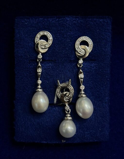 Juego de pendientes largos con colgante de perlas y circonitas. Montado en oro blanco de ley 18kts.