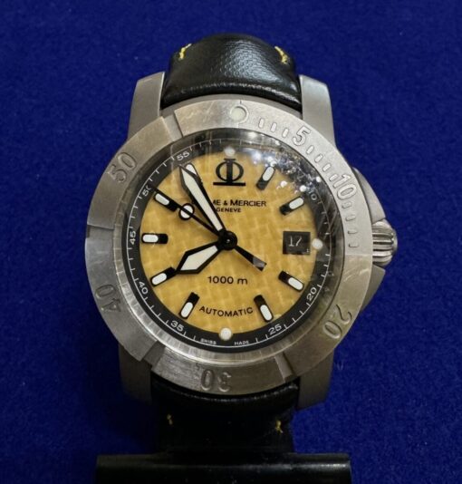 Reloj Baume & Mercier Geneve 1000M automático. Modelo Capiland XXL. Montado en titanio con correa de piel. Esfera amarilla de 43mm. Sin caja ni documentos originales.