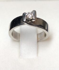 Solitario con brillante de 0,17cts montado entre brazos cruzados. En oro blanco de ley 18kts.