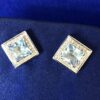 Pendientes topacio azul rodeados de carril  brillantes  montados en oro blanco de ley 18 Kts.