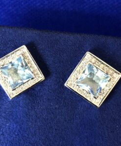 Pendientes topacio azul rodeados de carril  brillantes  montados en oro blanco de ley 18 Kts.