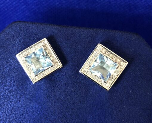 Pendientes topacio azul rodeados de carril  brillantes  montados en oro blanco de ley 18 Kts.