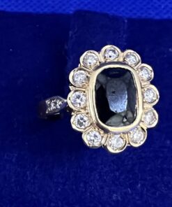 Sortija con zafiro fino rodeado de orla con brillantes auténticos montado en oro amarillo 18 kts.