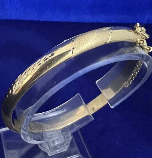 Pulsera media caña labrada montada en oro de ley 18 kts.