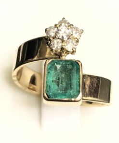 Sortija con esmeralda colombiana de 3,50 cts. (aprox.) y estrella de brillantes 0,26 cts. (aprox.) en total, montada en oro de ley 18 kts.