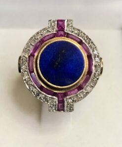 Sortija circular Art Decó con lapislázuli central en doble orla de rubíes y diamantes, en oro amarillo de ley 18 kts.