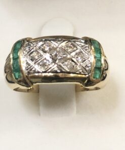 Sortija de oro amarillo de ley 18 kts con bandas de auténticas esmeraldas colombianas en carré y teselado central de motivos geométricos con brillantes en vista en oro blanco.