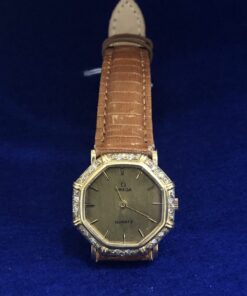 Reloj Omega vintage de señora, forma octogonal con brillantes y caja en oro de ley 18 kts. Mecanismo de cuarzo, pulsera de piel marrón.