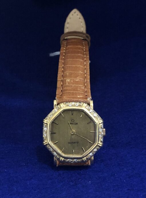 Reloj Omega vintage de señora, forma octogonal con brillantes y caja en oro de ley 18 kts. Mecanismo de cuarzo, pulsera de piel marrón.