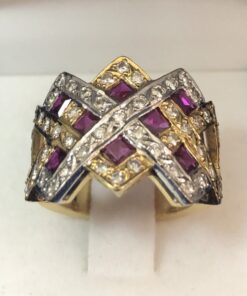 Sortija con motivos geométricos en oro blanco y oro amarillo de ley 18 kts, entrelazados, con brillantes engastados y rubíes en carré