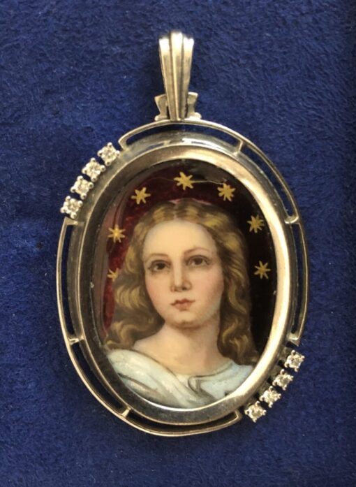 Colgante con esmalte policromado de Madonna coronada de estrellas y brillantitos de 0'25 cts en total, realizado en oro blanco de ley 18 kts.