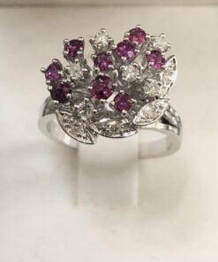Sortija de brillantes y rubíes en forma de florecitas y hojas , en oro blanco de ley 18 kts.