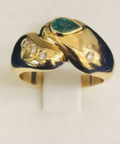 Sortija con auténtica esmeralda colombiana talla oval y cuatro brillantitos de 0,0'8 cts en total, en oro amarillo de ley 18 kts.