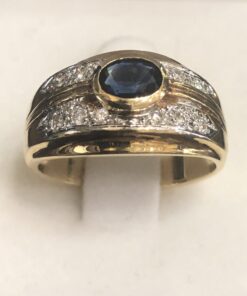 Sortija vintage con zafiro tallado central y doble línea de brillantes de 0'12 cts en total, montados en oro amarillo de ley 18 kts.