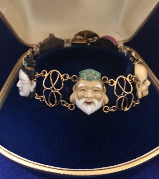 Pulsera toshikane con cinco motivos en porcelana de los dioses japoneses de la fortuna y cierre de caja, en filigrana de oro de ley 18 kts.