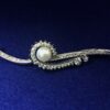 Broche vintage (años 60) con motivos orgánicos y perla cultivada al centro, enriquecido con 1'40 cts de brillantes, en oro blanco de ley 18 kts.