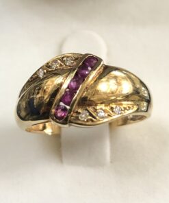 Sortija vintage (años 80) con original diseño diagonal de rubíes y brillantes en lados opuestos de cada brazo, en oro amarillo de ley 18 kts.