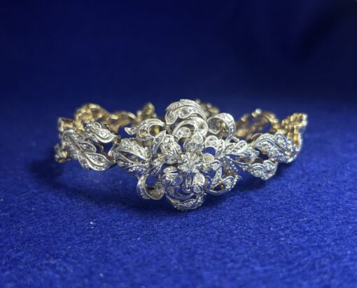 Pulsera vintage (años 60), vistas en oro blanco con roleos y motivo floral al centro, enriquecida con 1'80 cts de diamantes, en oro de ley 18 kts.