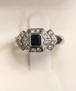 Sortija moderna de estilo Art Decó con 0'40 cts de brillantes y un zafiro central en talla carré de 0'30 cts en oro blanco de ley 18 kts.