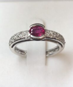 Sortija con rubí central de 0'50 cts y brillantitos laterales (0'26 cts en total), en oro blanco de ley 18 kts.