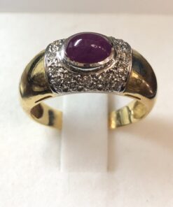 Sortija con rubí central en cabujón, enriquecida con 0'20 cts de brillantitos en oro amarillo de ley 18 kts.