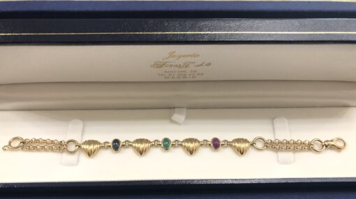 Pulsera con eslabones en forma de corazón estriado con cabujones de zafiro, esmeralda y rubí naturales, en oro amarillo de ley 18 kts. - Imagen 2