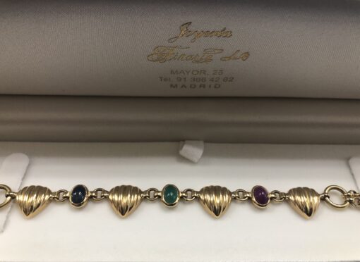 Pulsera con eslabones en forma de corazón estriado con cabujones de zafiro, esmeralda y rubí naturales, en oro amarillo de ley 18 kts.