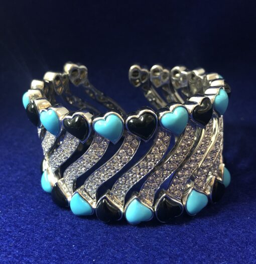 Hermoso brazalete con 8'40 cts en total de brillantes, con corazones de turquesas y ónix, en oro blanco de ley 18 kts.