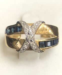 Sortija con zafiros en carré y motivo en forma de cruz cuajada de brillantes, en oro amarillo de ley 18 kts.