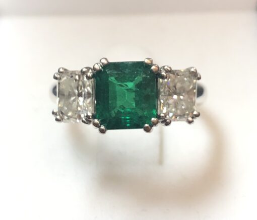 Importante sortija tresillo con 2 brillantes laterales talla princesa de 1'70 cts en total y auténtica esmeralda colombiana de 1'40 cts en oro blanco de ley 18 kts.