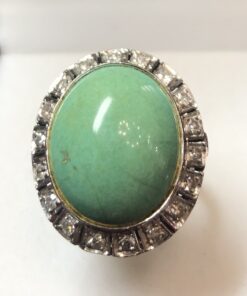 Sortija con cabuchón de turquesa verde central y orla de diamantes en oro blanco de ley 18 kts.