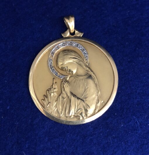 Medalla de 30 mm de diámetro de la Virgen Niña con aureola de diamantitos en oro amarillo de ley 18 kts.