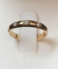 Alianza de oro amarillo de ley 18 kts, con detalles cincelados en forma de estrellas y 3 brillantes de 0'10 cts (aprox.) en total.