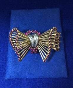 Broche retro en forma de lazada con con 0'12 cts de brillantes y rubíes reconstituidos en oro amarillo de ley 18 kts.