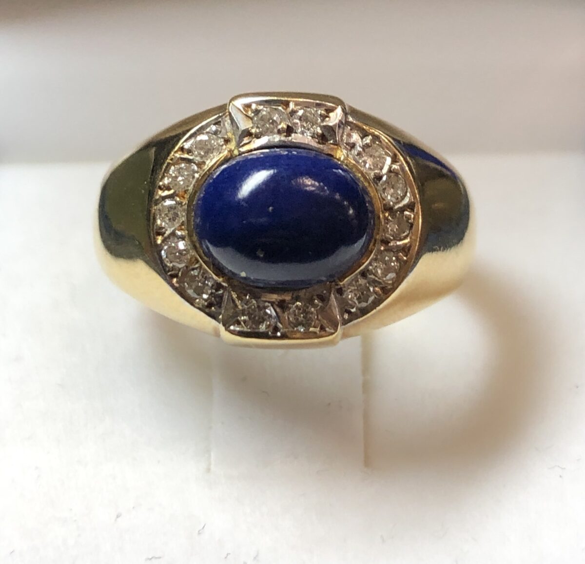 Sortija tipo sello con cabujón de lapislázuli y orla de brillantes (0'28 cts en total), en oro amarillo de ley 18 kts.